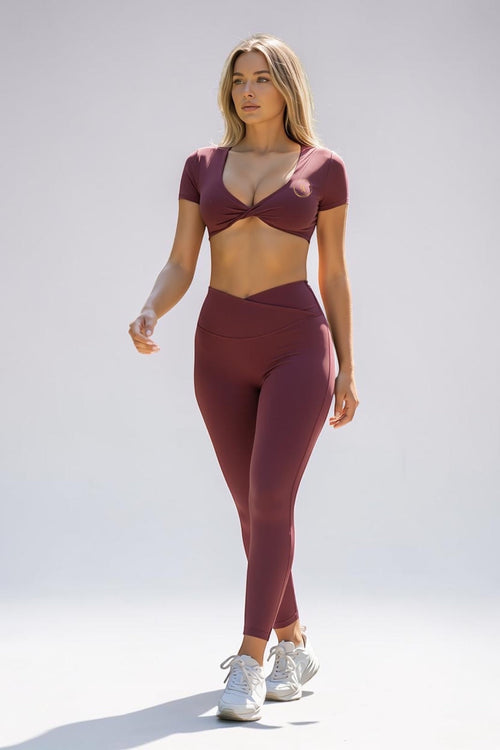 Drvyn Apparel Define Twist Sports Bra in wine, made from nylon and spandex blend, with V-neck and open back.