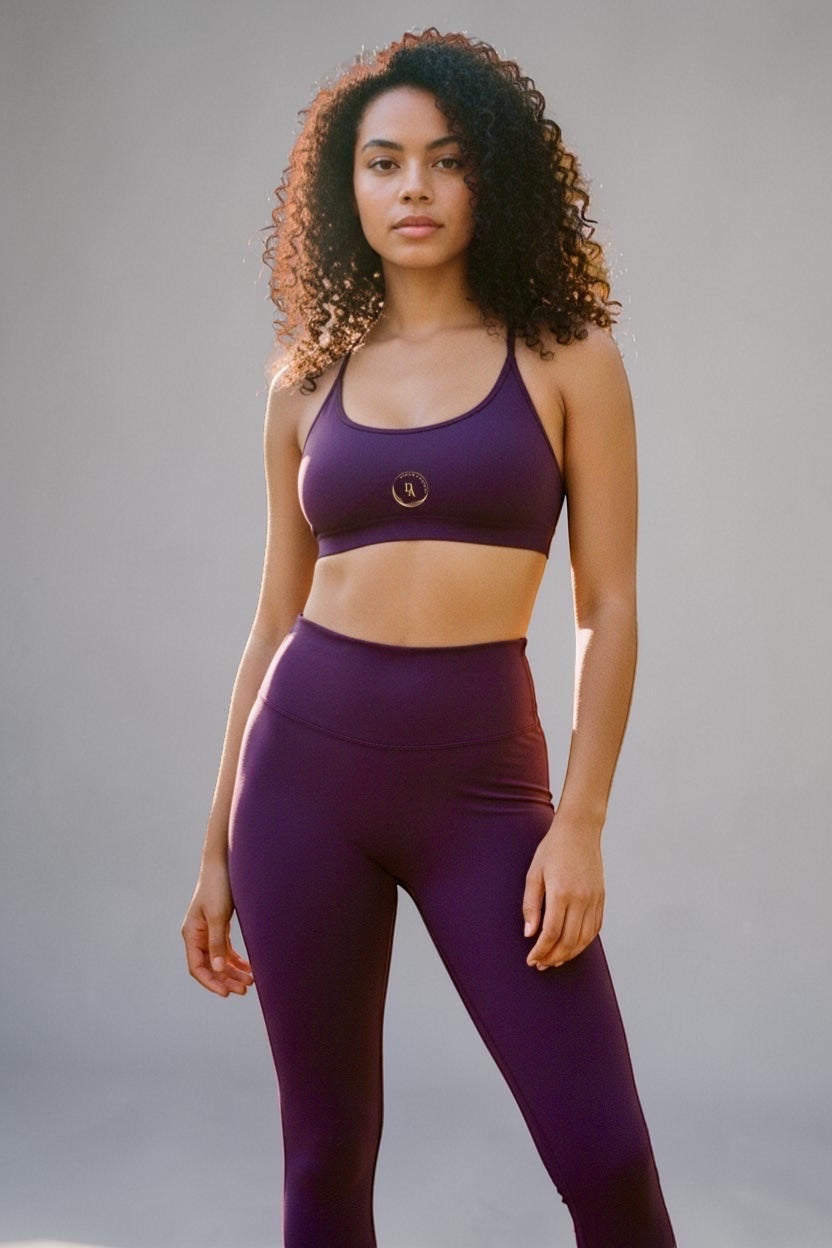Drvyn Apparel plum purple nylon-spandex sports bra with strappy back and scoop neckline.