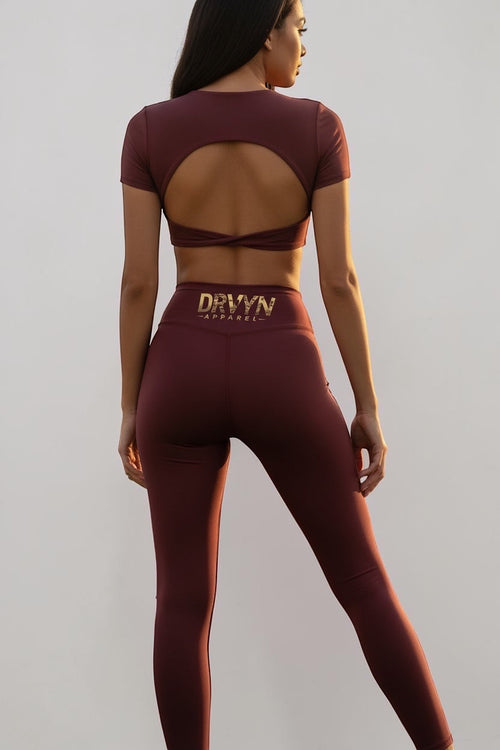 Drvyn Apparel women's wine-colored high-rise nylon-spandex leggings with a sculpting fit and cutout back top.